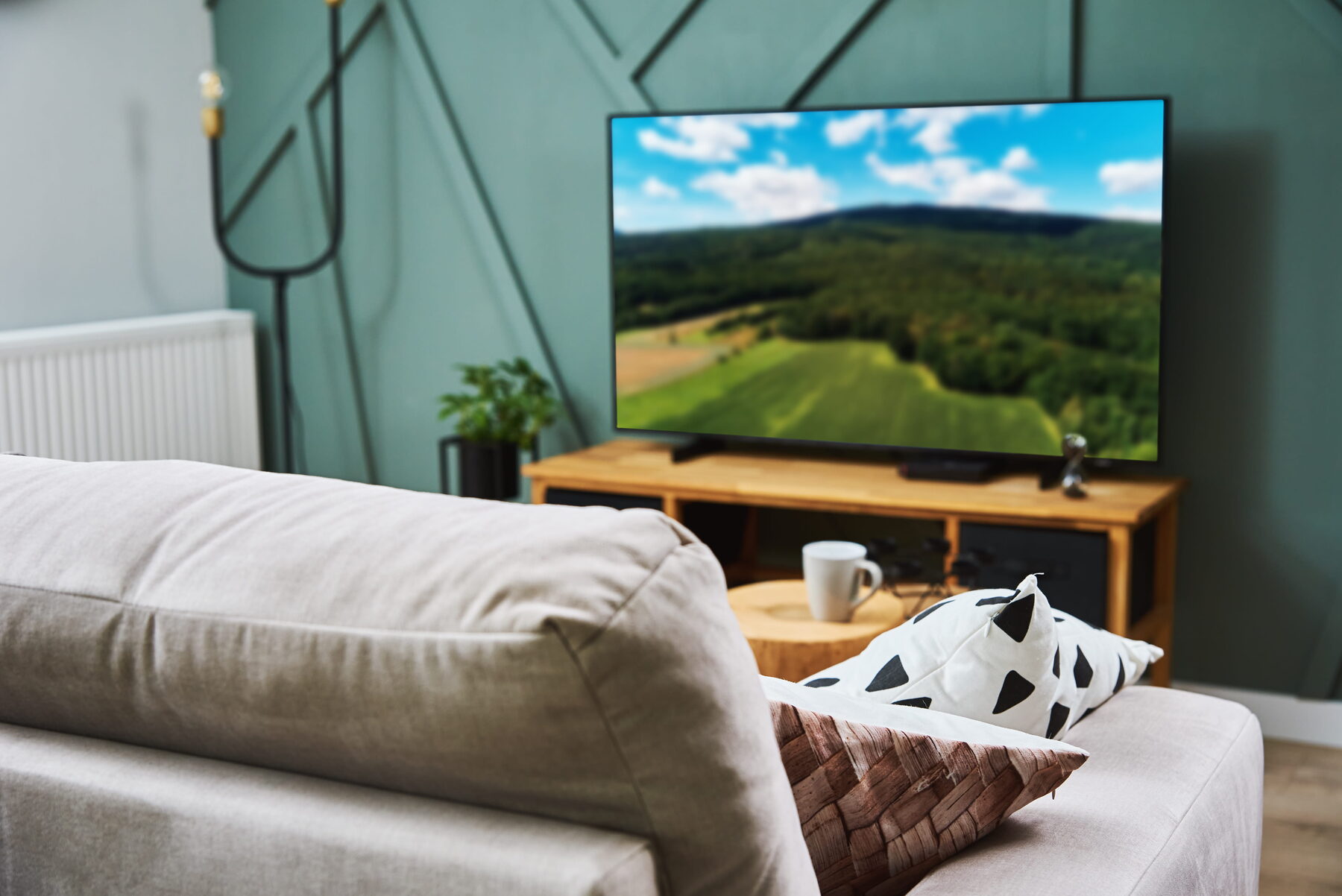 Curved television displaying a wide landscape image in a lounge