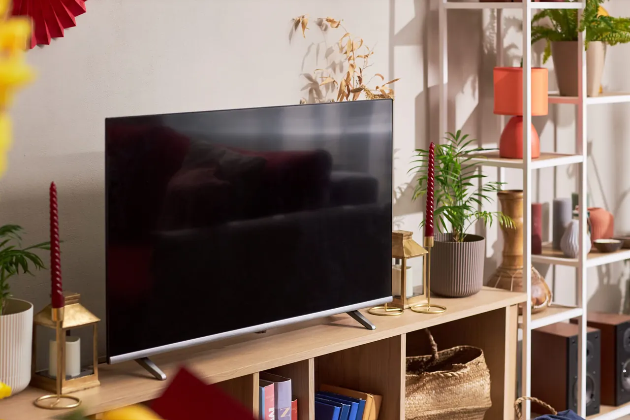 Flat screen television mounted on a lounge wall with the screen switched off