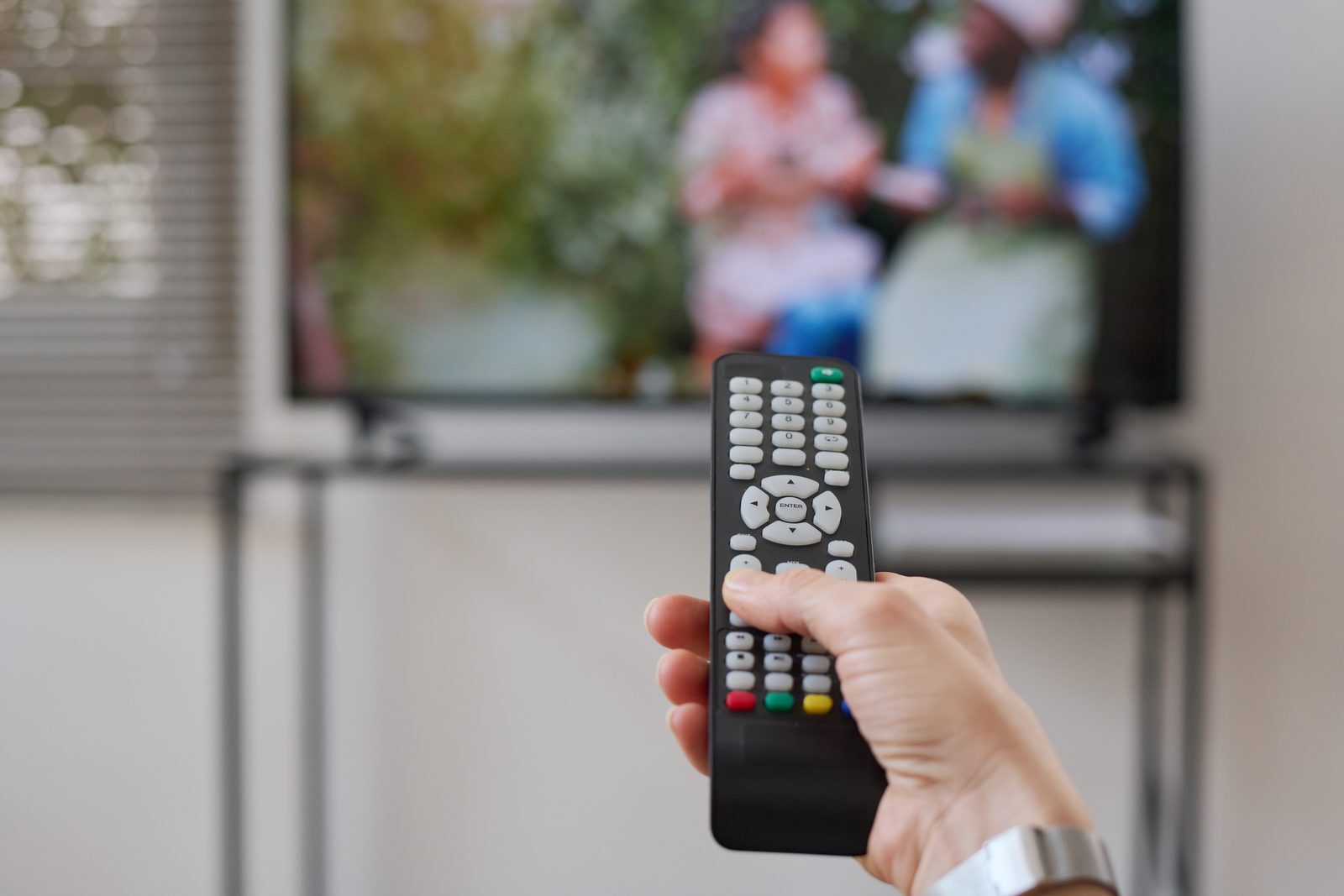 Person holding a TV remote control that has stopped responding to the television