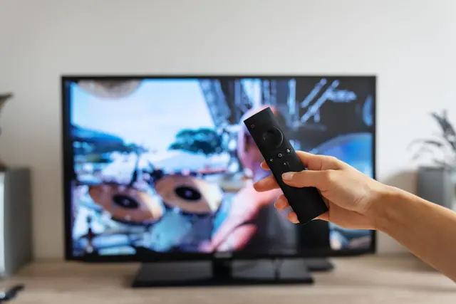 Hand holding a television remote control that is not responding
